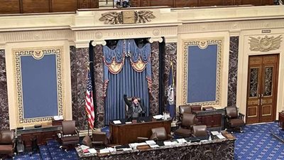 متظاهر يجلس على كرسي رئيسة مجلس النواب الأمريكي نانسي بيلوسي | صور