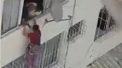 أمرأة تنقذ طفلا سقط من طابق عال على مظلة (فيديو)