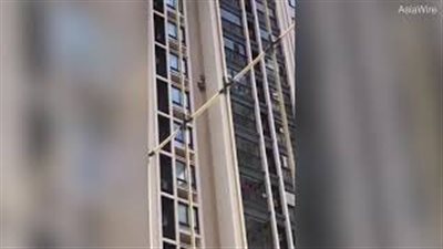 شاب يحاول إنقاذ نفسه بعد سقوطه من مبنى شاهق الارتفاع (فيديو)