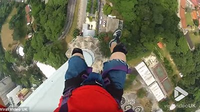 متهور يسير أعلى حبل معلق بين ناطحة سحاب ورافعة (فيديو وصور)