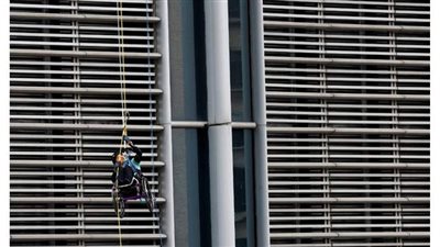 على كرسي متحرك.. شخص يتسلق ناطحة سحاب في هونج كونج