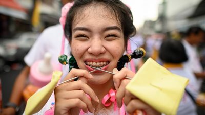 «آلهة الإمبراطور».. مشاركون يشوهون وجوههم لحمل الأسلحة في مهرجان تايلاندي(صور)