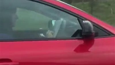 سائق يعرض حياته للخطر باستخدام هاتفه (فيديو وصور)