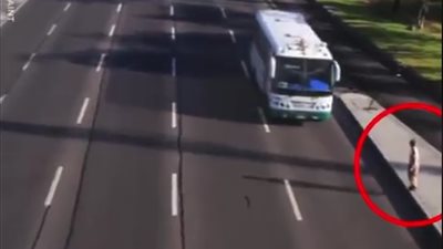 متهور يعبر طريقا سريعا من أسفل السيارات (فيديو)