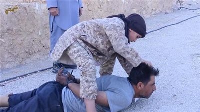 بالفيديو والصور.. صبي داعشي يذبح ضابطا سوريا