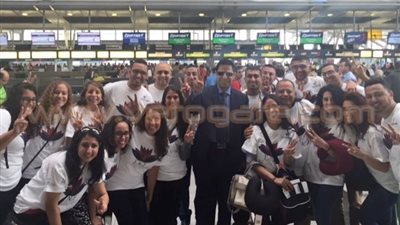 وفد المصريين بالمهجر يرفع علامة النصر بعد وصولهم القاهرة