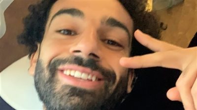 محمد صلاح يشير بعلامة النصر بطائرة العودة للقاهرة