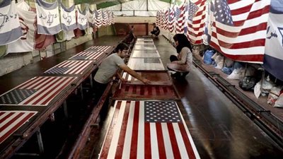 سبوبة بالحريقة.. حكاية مصنع إيراني يصنع أعلام أمريكا وإسرائيل لحرقها | صور