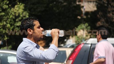 بالصور.. «كاب وشمسية وخرطوم مياه» أسلحة المصريين أمام الموجة الحارة