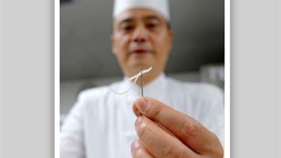 شيف صيني يقطع البطاطس على بالون وهو معصوب العينين (فيديو وصور)