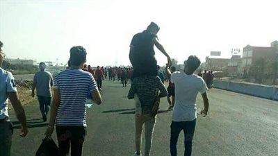 مشجع أهلاوي يحمل صديقه المصاب لحضور مباراة القطن