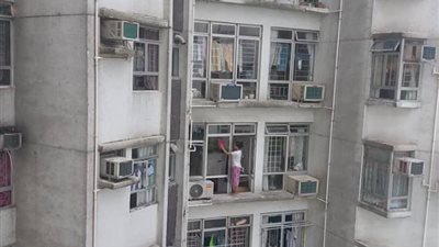 عاملة منزل تخاطر بحياتها لتنظيف نافذة تقع في الطابق الـ23 (صور)