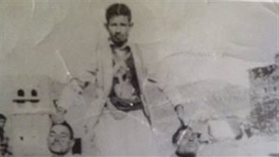 بالصورة.. مسلح يمني حوثي يحمل رءوس جنود مصريين مقطوعة