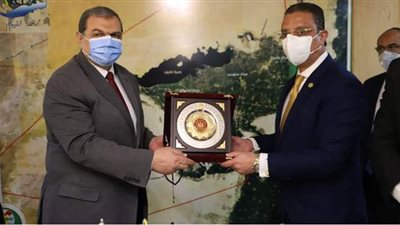 سعفان ومحافظ الفيوم يتبادلان الدروع خلال تسليم بوالص التأمين للعمالة