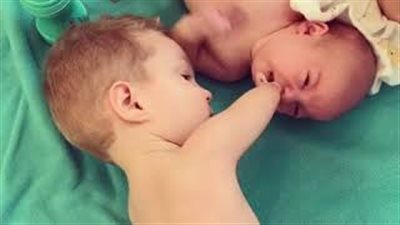 بالفيديو.. طفل فاقد ذراعيه يساعد شقيقه الرضيع يشعل مواقع التواصل