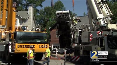 بالصور.. رافعة تقسم منزلا لنصفين بعد سقوطها أعلاه