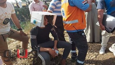 شاب يحتمى من حرارة الشمس الحارقة بكرتونة في موقع حادث قطار طوخ