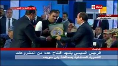 شاب يهدي السيسي درعا أثناء افتتاح عدد من المشروعات ببني سويف