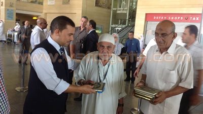 بالصور.. جمارك مطار برج العرب توزع المصاحف على الحجاج العائدين