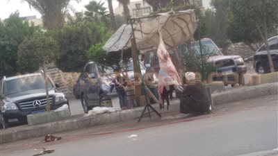 بالصور.. جزار يفترش الطريق العام بمدينة العبور