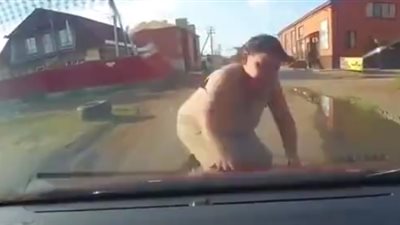 امرأة تخاطر بحياتها وتلقي بنفسها أمام سيارة للحصول على المال (فيديو)