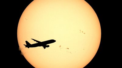 صور «مبدعة» لطائرة تحلق أمام قرص الشمس