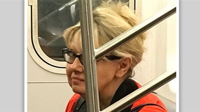 امرأة تجلس أعلى مشرد بمترو الأنفاق (صور)