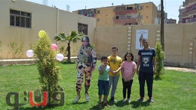 أبناء الشهيد المنسي يلتقطون صورا مع مجسم والدهم بـ