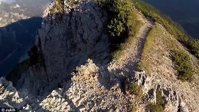 بالفيديو والصور.. راكب دراجة متهور يخاطر بحياته أعلى قمة جبل