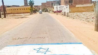 علم إسرائيل تدهسه الأقدام بمدخل قرية «هليه» ببني سويف