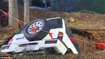 بالصور..  بالوعة صرف تبتلع سيارة شاب وفتاة