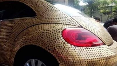 بالصور.. امرأة تغطي سيارتها بـ10 آلاف عملة نقدية!!