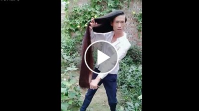 رجل يستخدم شعره شديد الطول كحبل أرجوحة (فيديو)