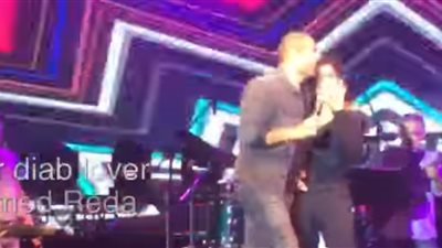 قبلات بين عمرو دياب ودينا الشربيني على «برج الحوت» بحفل جامعة مصر (فيديو)