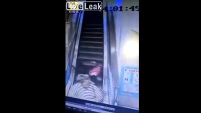 سقوط مروع لعجوز يحمل طفل ويصعد السلم الكهربائي (فيديو)