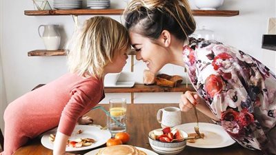 بالصور.. امرأة لا تمانع مشاركة طفلها في إعداد الطعام بالمطبخ