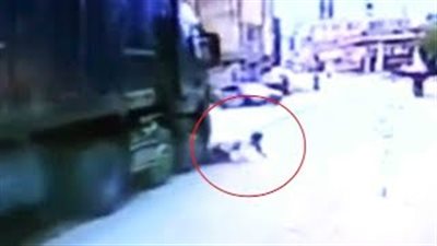 سائق موتوسيكل يفلت من تحت شاحنة بأعجوبة (فيديو)