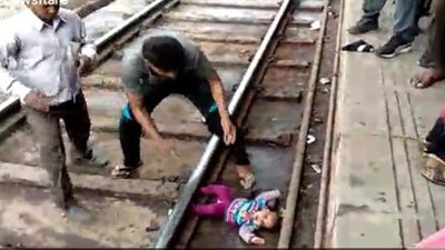 لحظة سقوط رضيعة من والدتها تحت عجلات قطار (فيديو)
