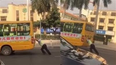 لقطات مذهلة لضابط مرور يدفع حافلة مدرسية بمفرده على الطريق (فيديو)
