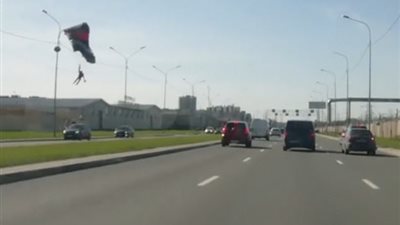 رجل عَلَقَت مظلته الهوائية بعامود إنارة (فيديو وصور)