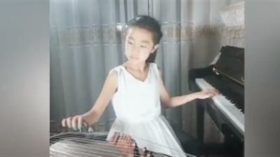 طفلة تعزف على آلتين في آن واحد (فيديو)