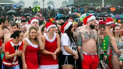 بالبكيني وملابس بابا نويل.. محتفلو الكريسماس يتحدون برودة الطقس بالسباحة (صور)