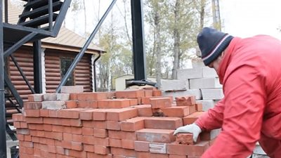 عامل بناء يقطع قوالب الطوب بيديه العاريتين (فيديو وصور)