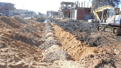 بالصور.. تغطية مصرف زراعى بالتل الكبير