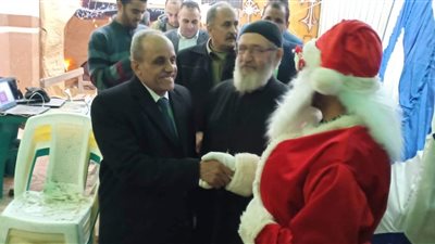 بابا نويل يلتقط صورا تذكارية مع المهنئين أمام إبراشية مارجرجس بالقليوبية