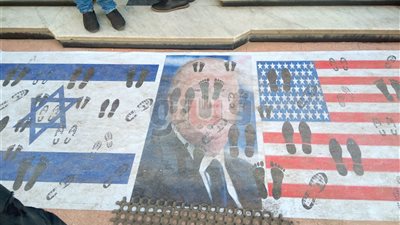 صاحب محل أحذية يضع علمي أمريكا وإسرائيل أمام الباب (فيديو وصور)