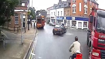 رجل يعرض حياة طفله للخطر بالمرور من بين شاحنتين (فيديو وصور)