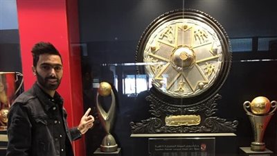 حسين الشحات يلتقط الصور التذكارية مع دولاب بطولات الأهلي