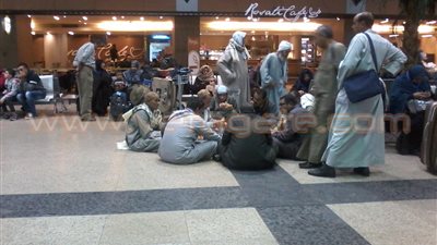 بالصور.. مواطنون يفترشون أرضيات صالة السفر بمطار القاهرة لتناول الطعام