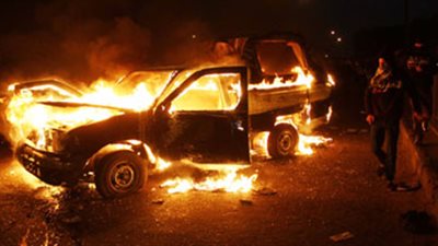 أعضاء الإرهابية يشعلون النيران بسيارة شرطة بأسوان